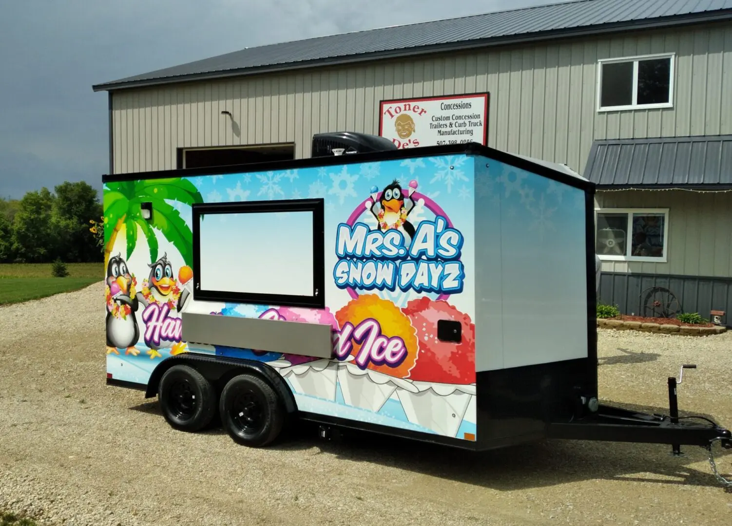 A trailer parked outside a warehouse with trees around