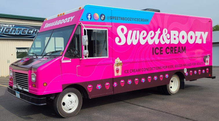 A pink van parked outside written sweet and boozy